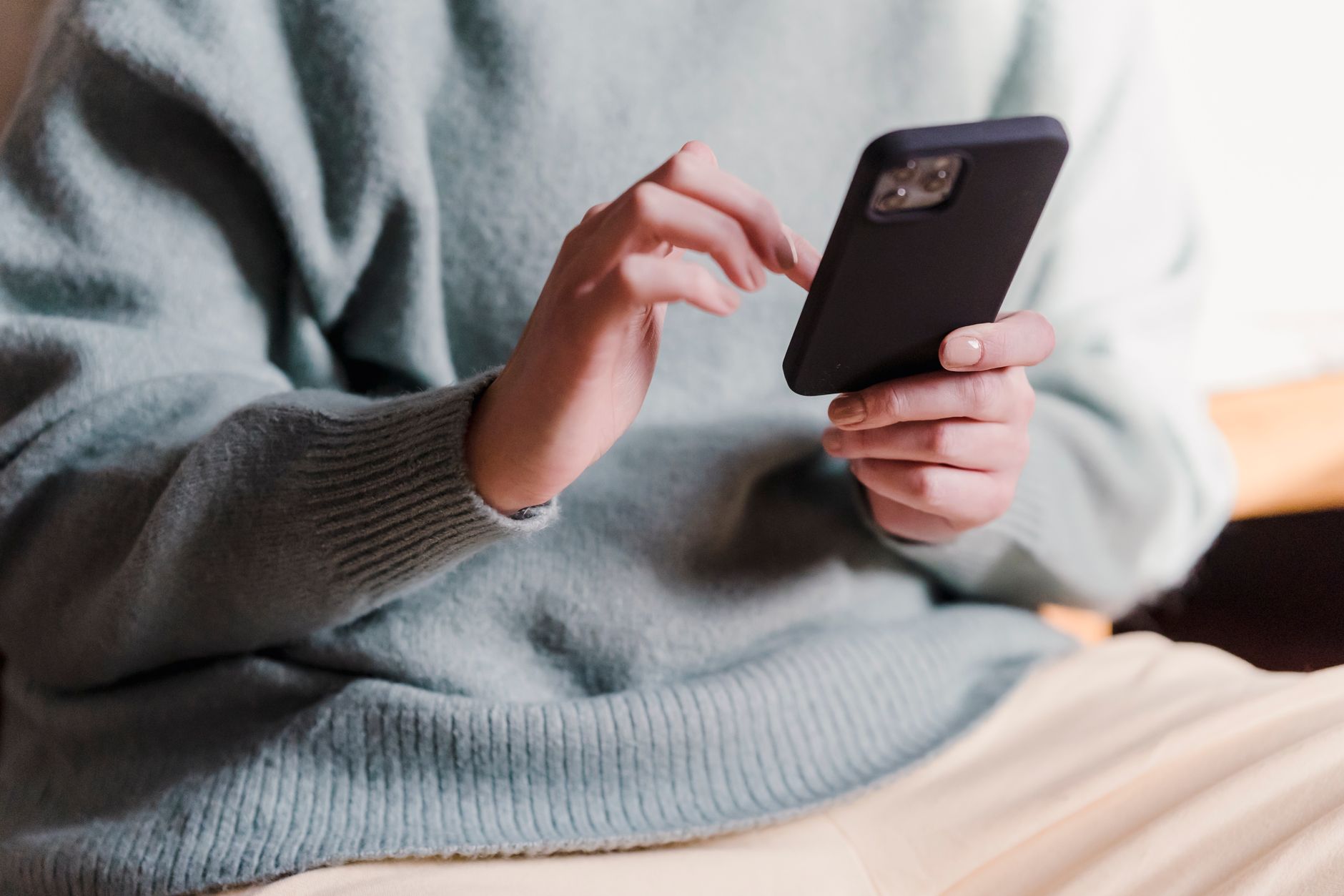 Une main tenant un smartphone avec des icônes de cadenas et de boucliers numériques